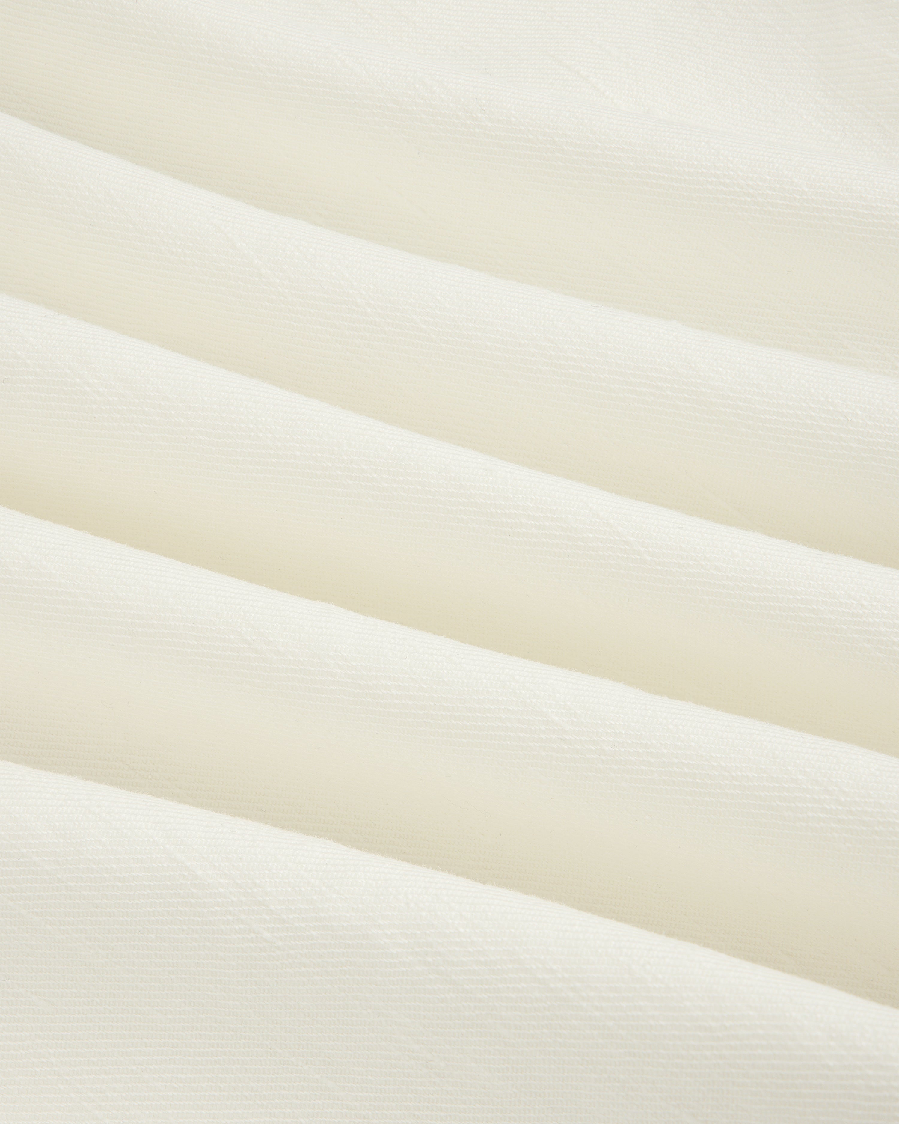 Close-up of Pleated Linen Blend Bermuda Short in white, featuring soft fabric with gentle horizontal folds.