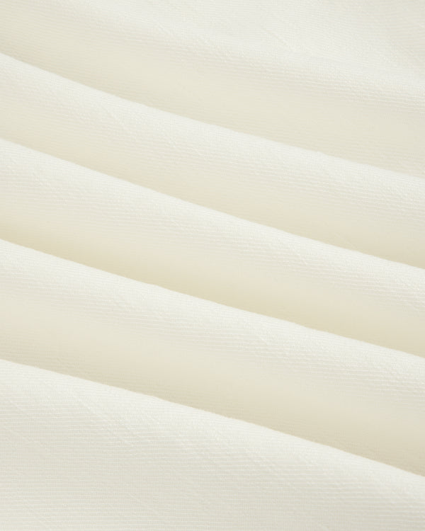 Close-up of Pleated Linen Blend Bermuda Short in white, featuring soft fabric with gentle horizontal folds.