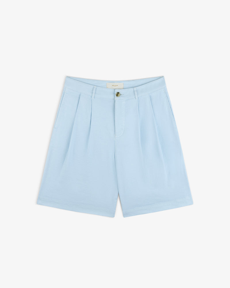 Pleated Linen Blend Bermuda Short in light blue with button and zip, front pockets, and belt loops on white background.