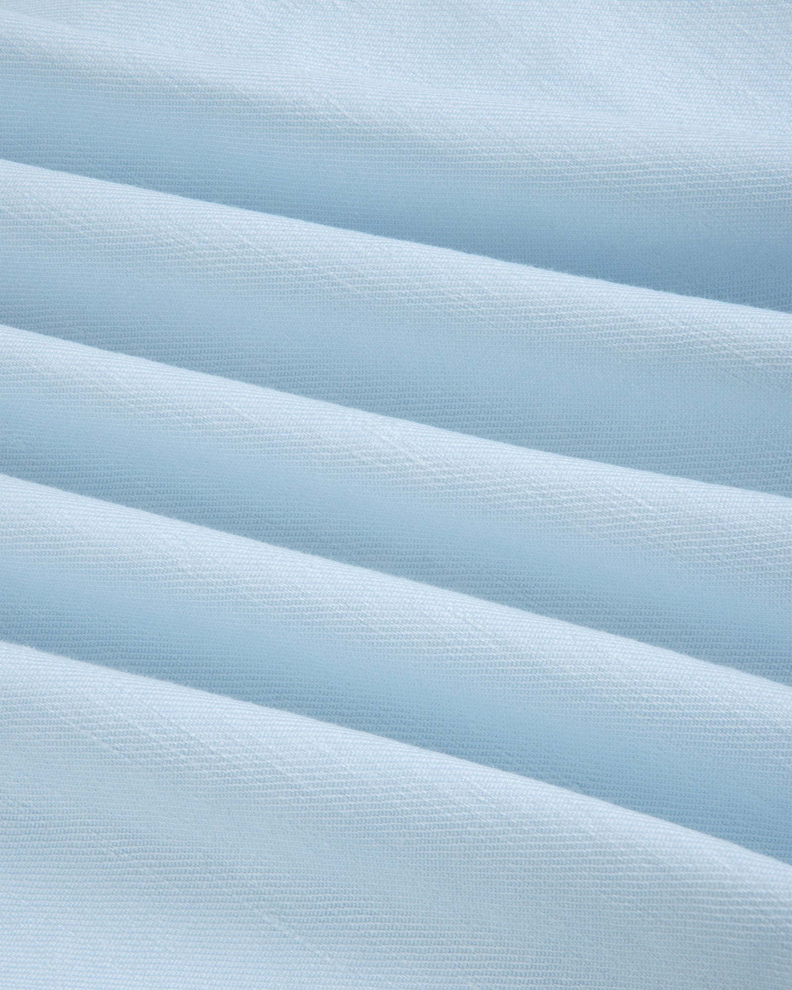 Close-up of Pleated Linen Blend Bermuda Short in light blue, showing soft folds and a textured surface.