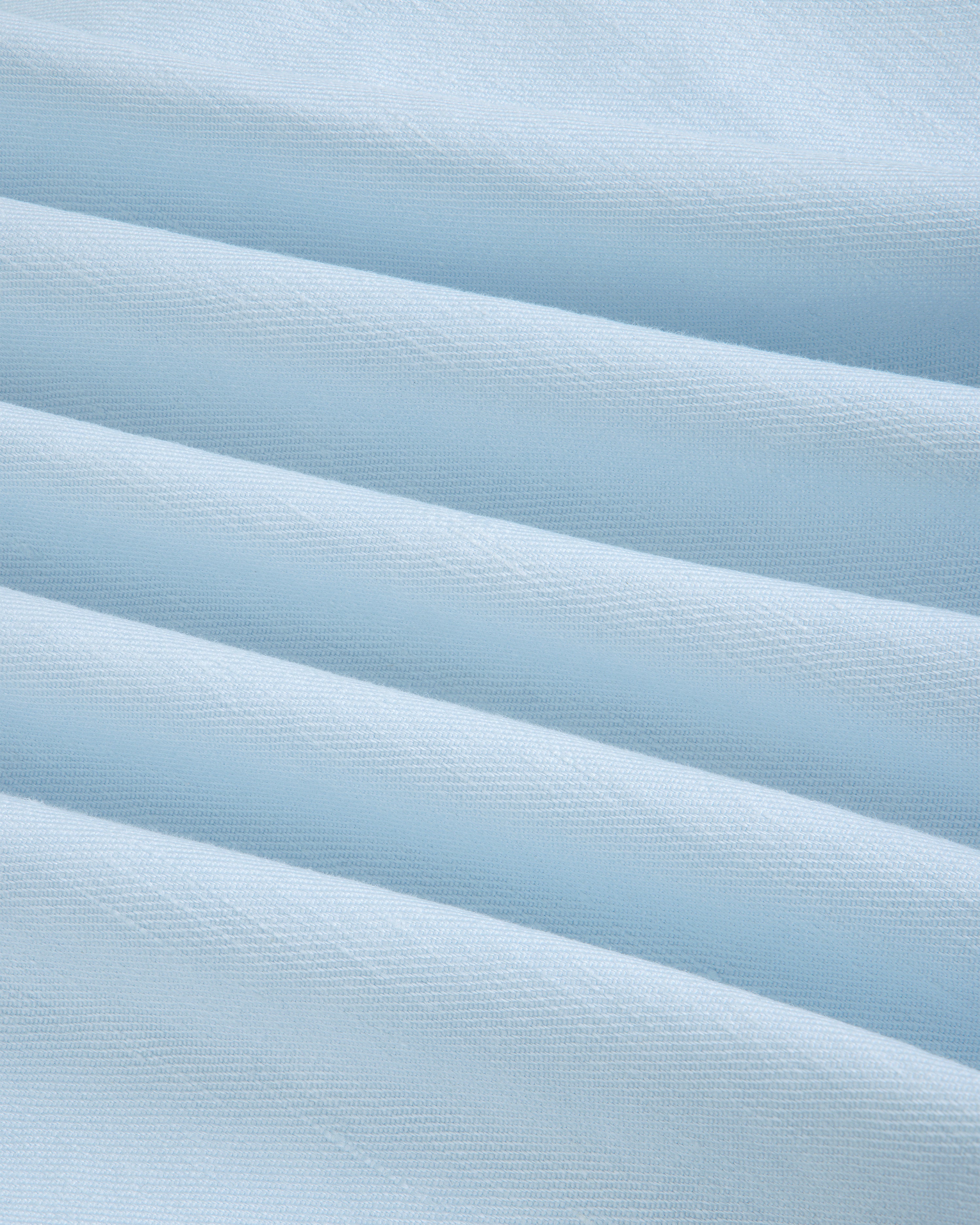 Close-up of Pleated Linen Blend Bermuda Short in light blue, showing soft folds and a textured surface.