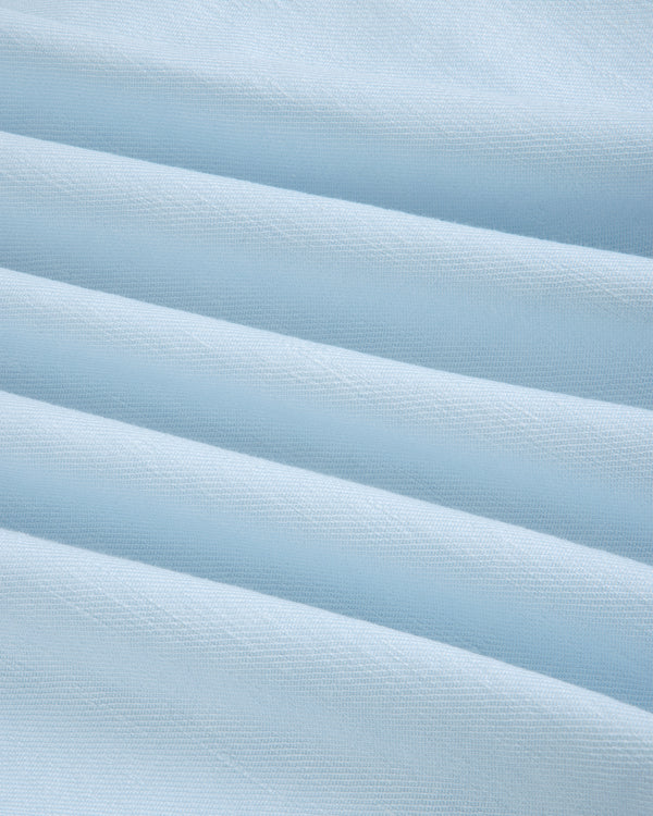 Close-up of Pleated Linen Blend Bermuda Short in light blue, showing soft folds and a textured surface.
