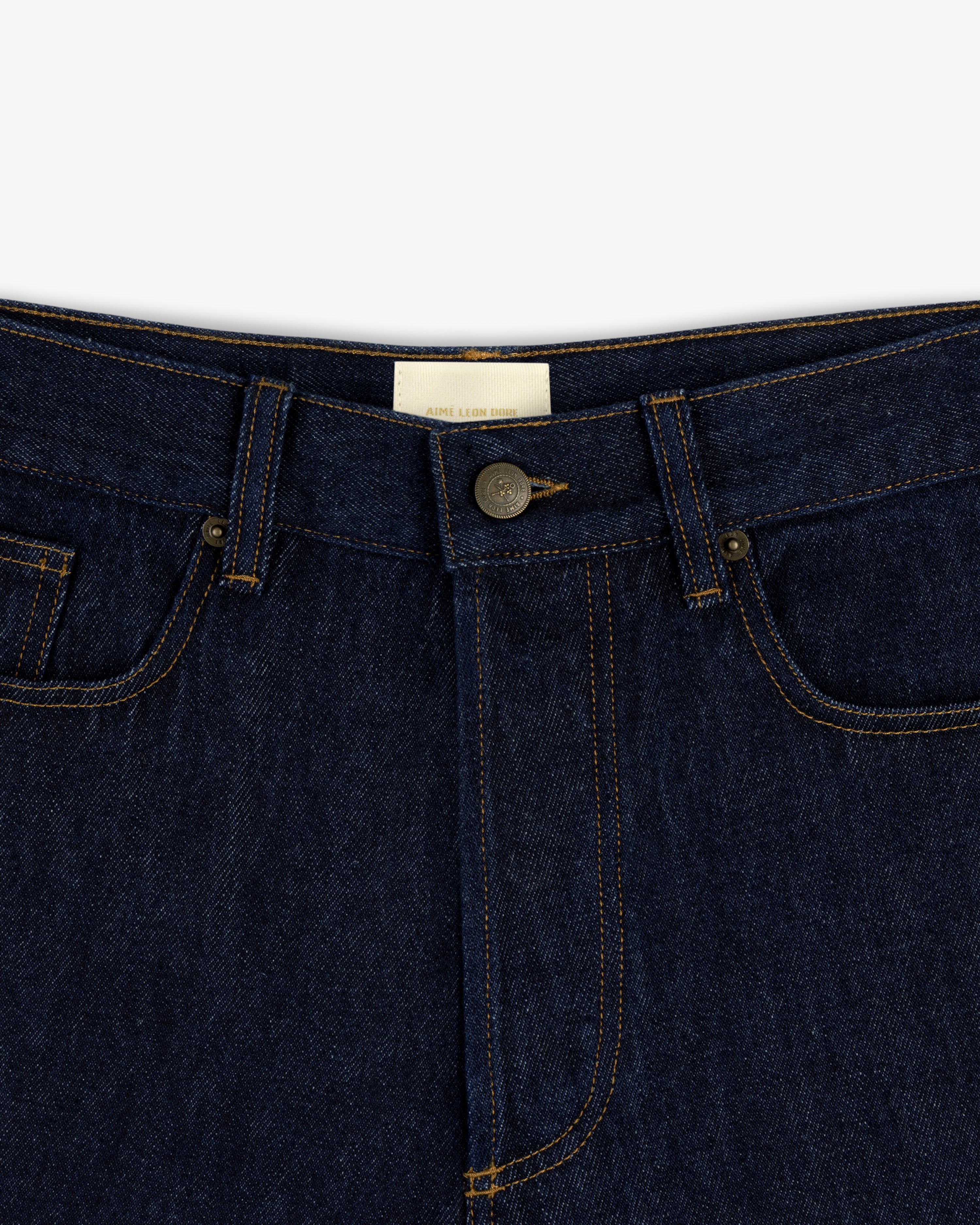 Close-up of the waistband and button of Rinse Wash Denim Short with yellow stitching.