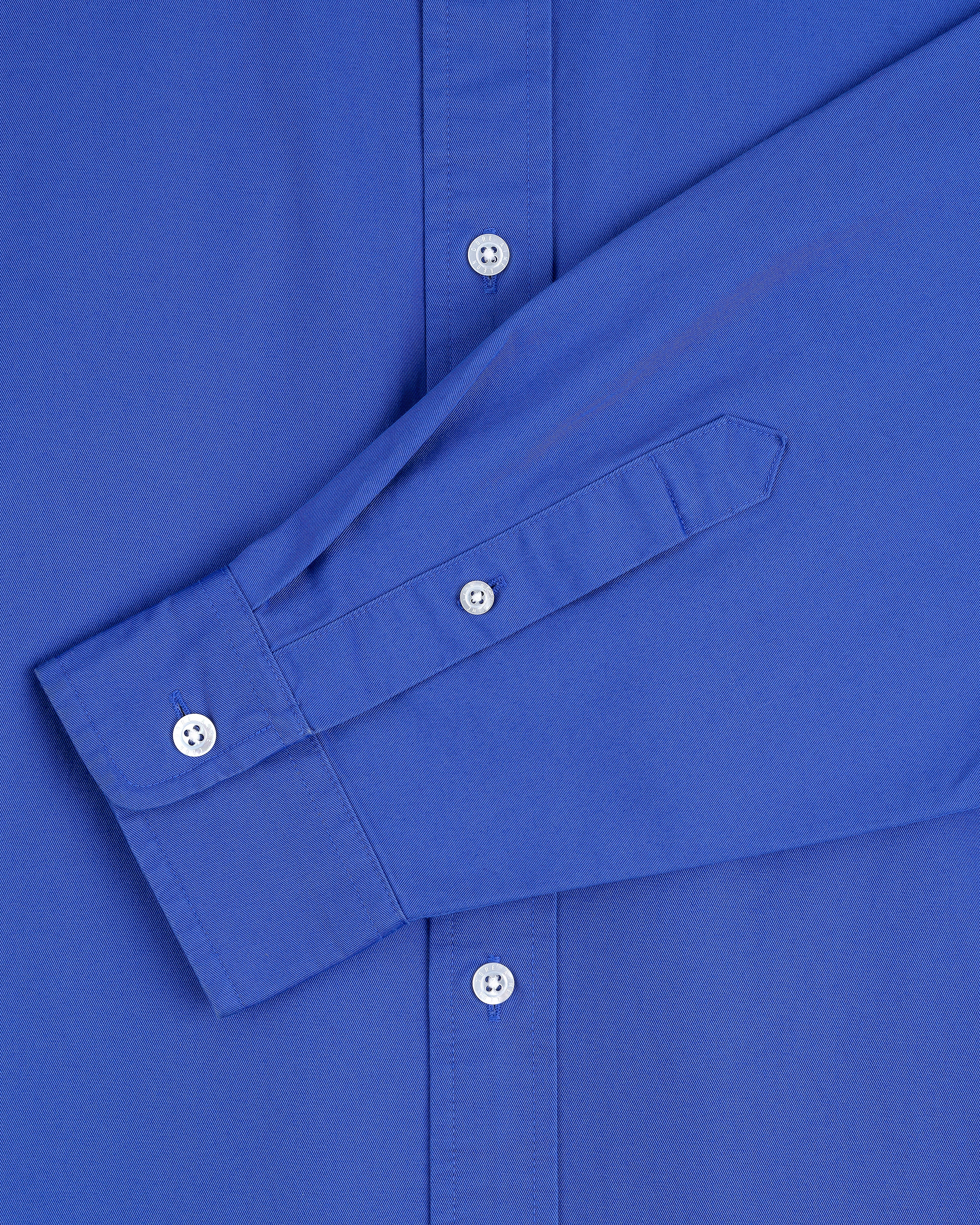 Close-up of the Leon Overshirt in blue, highlighting the sleeve and white buttons.