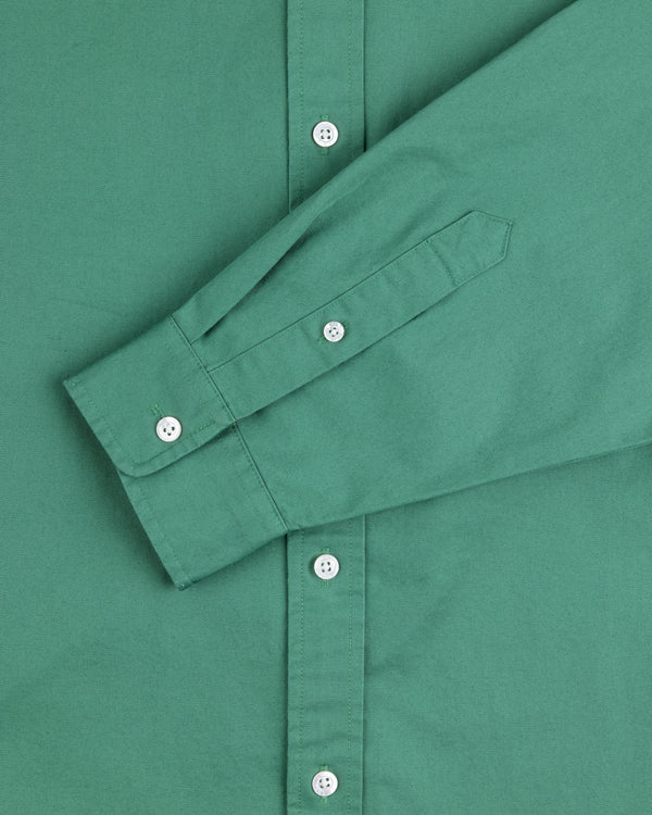 Leon Overshirt in green, front view with one sleeve folded, features white buttons and long sleeves.