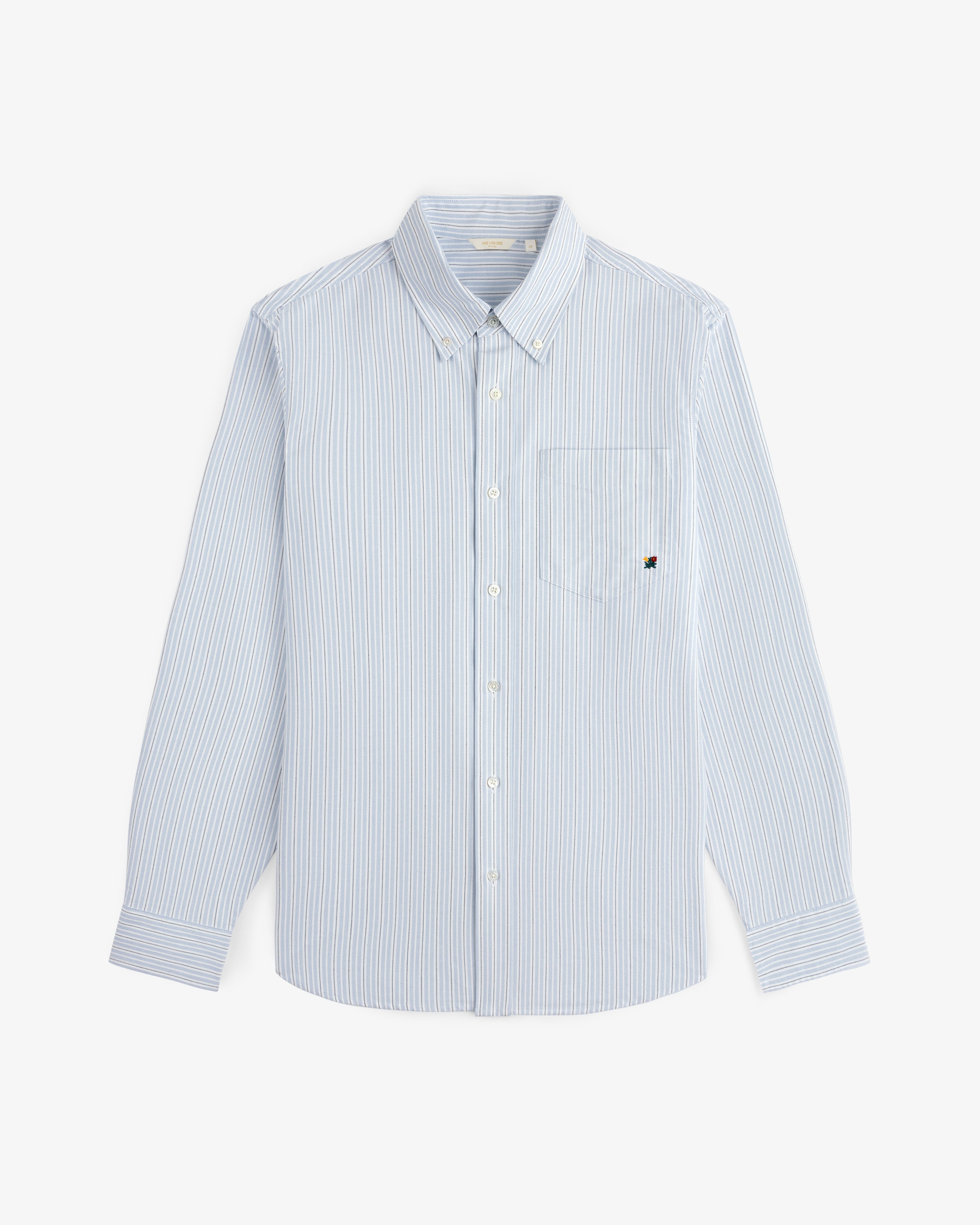 Yarn Dyed Striped Crest Shirt in light blue and white, long sleeves, button-up, front pocket, laid flat on white.