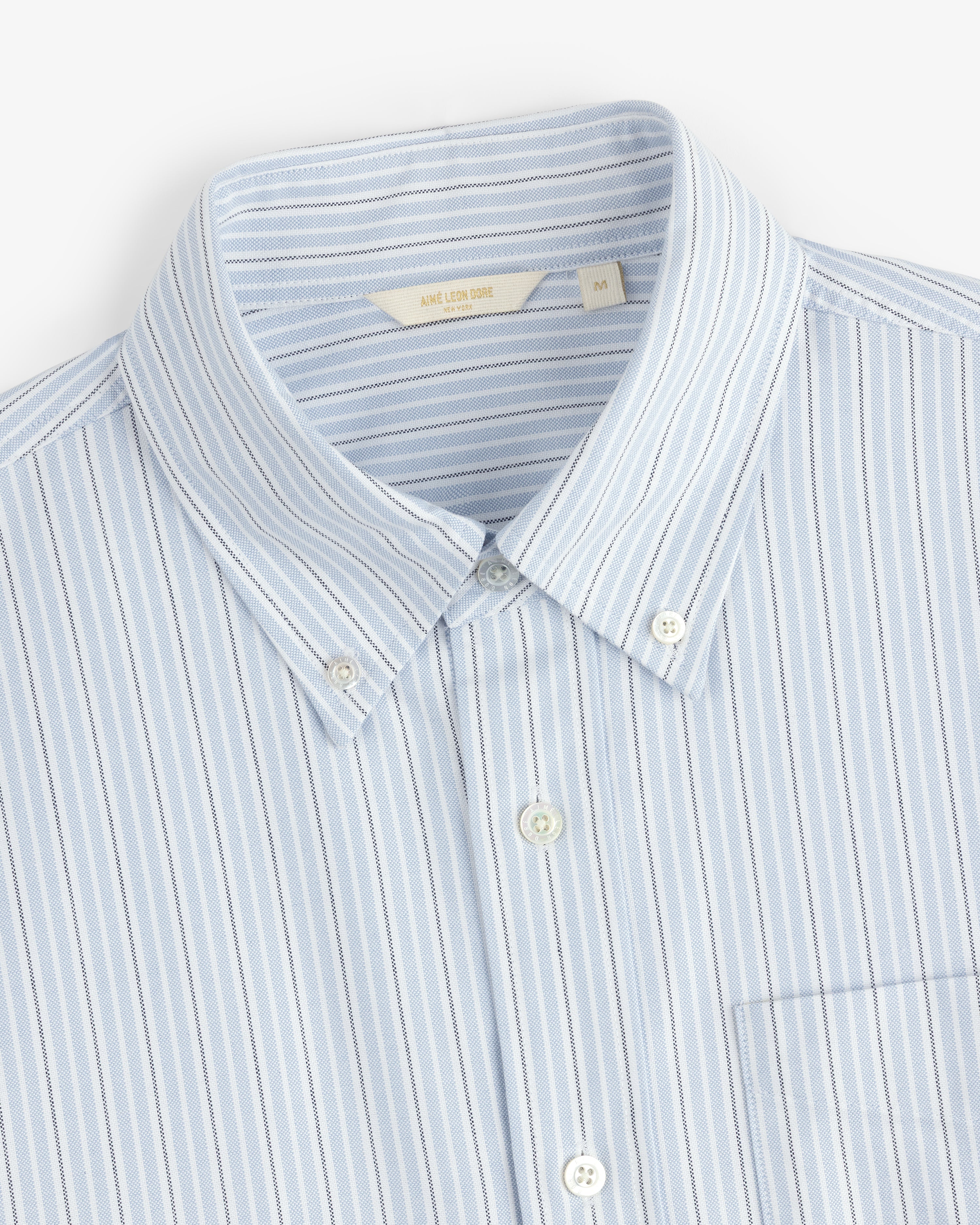 Yarn Dyed Striped Crest Shirt in light blue and white with a collar and front pocket, shown flat.