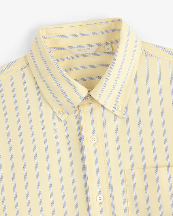 The Yarn Dyed Striped Crest Shirt features yellow, white, and blue vertical stripes, shown from the chest up.