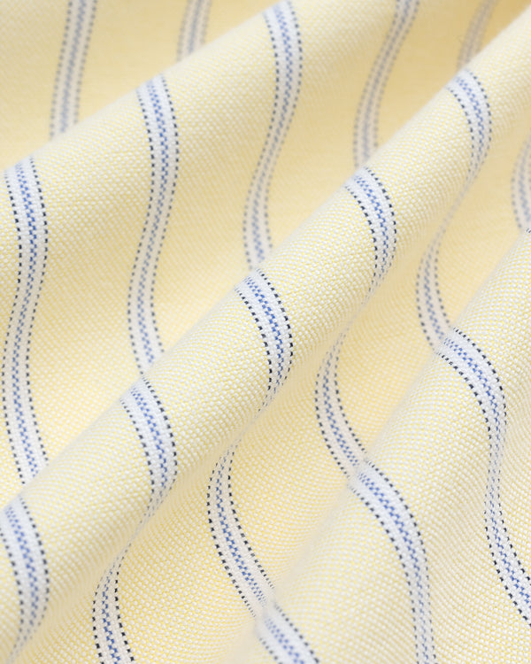 Close-up of Yarn Dyed Striped Crest Shirt fabric, featuring yellow with wavy blue stripes and a textured weave.