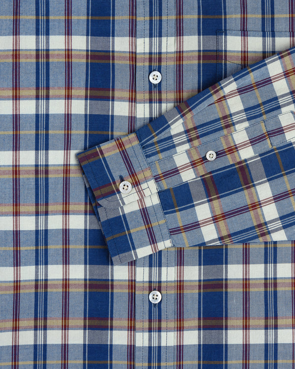 Washed Madras Shirt in blue, yellow, and white plaid with one sleeve folded diagonally across the chest.