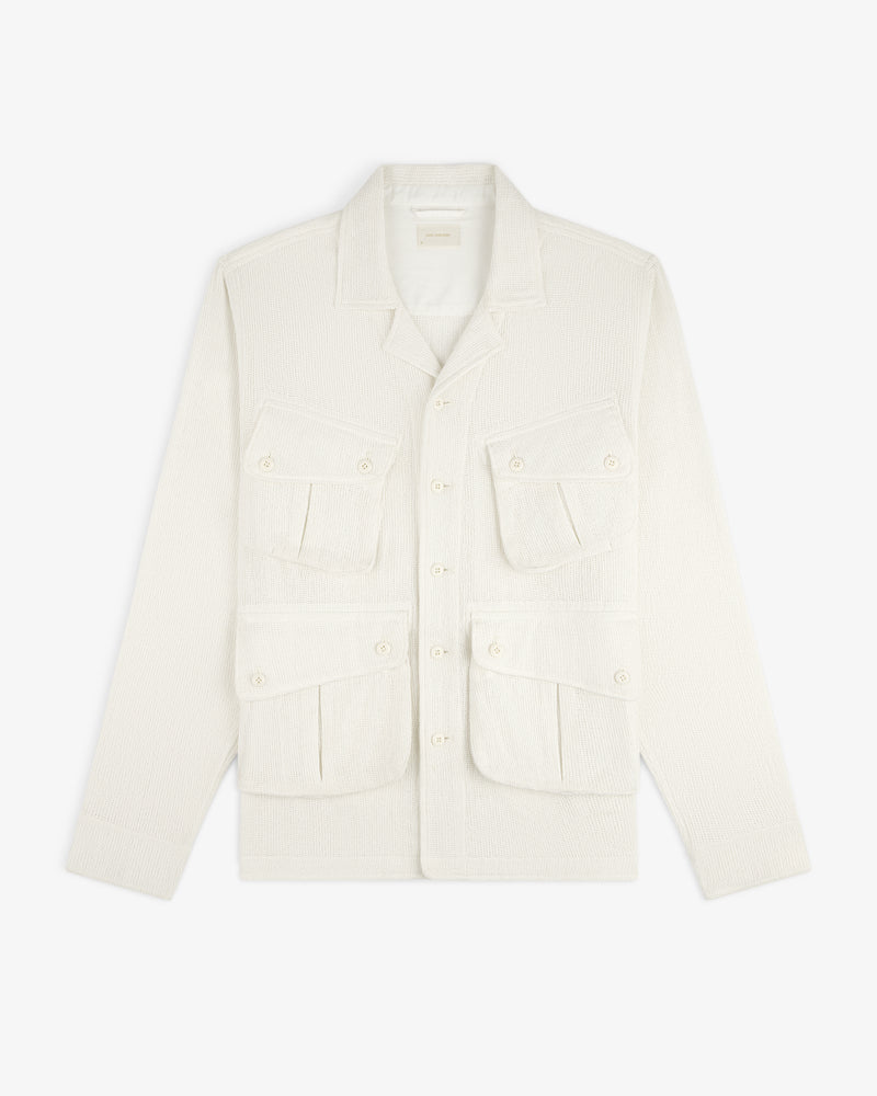Cream-colored Mesh Jungle Shirt with four front pockets and button closures, laid flat on a white background.