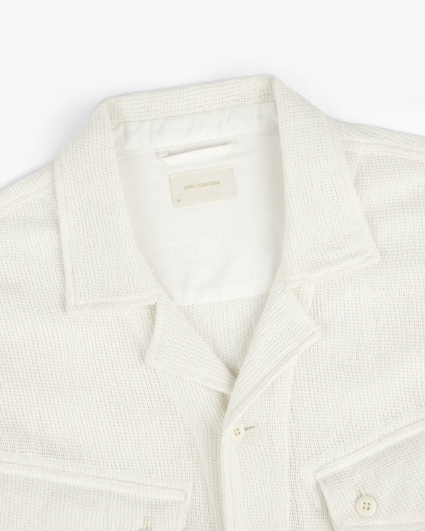 Cream-colored Mesh Jungle Shirt with collar, buttons, and front pockets on a white background.