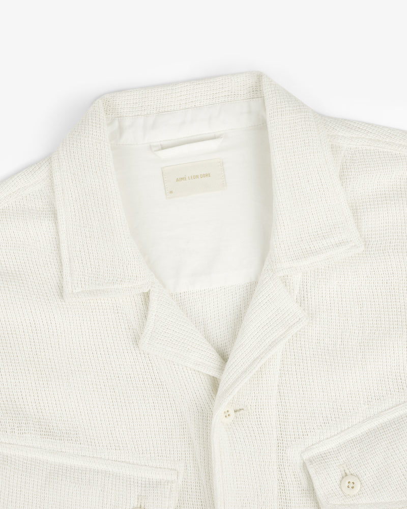 Cream-colored Mesh Jungle Shirt with collar, buttons, and front pockets on a white background.