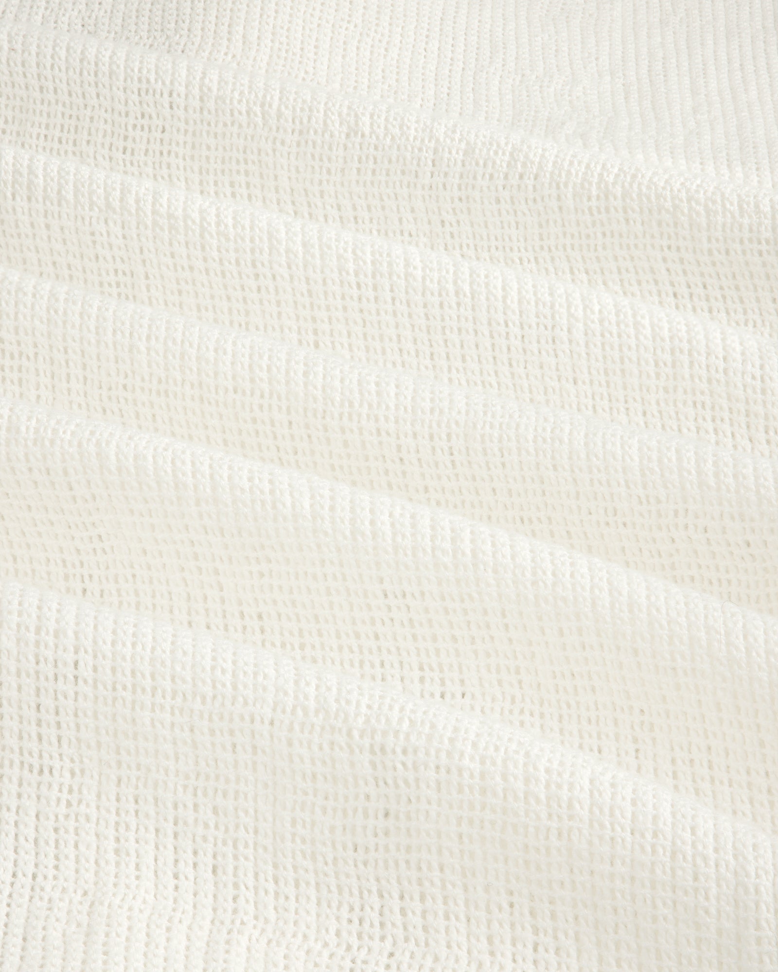 Close-up of the Mesh Jungle Shirt's white waffle-textured fabric with soft, grid-like ridges.