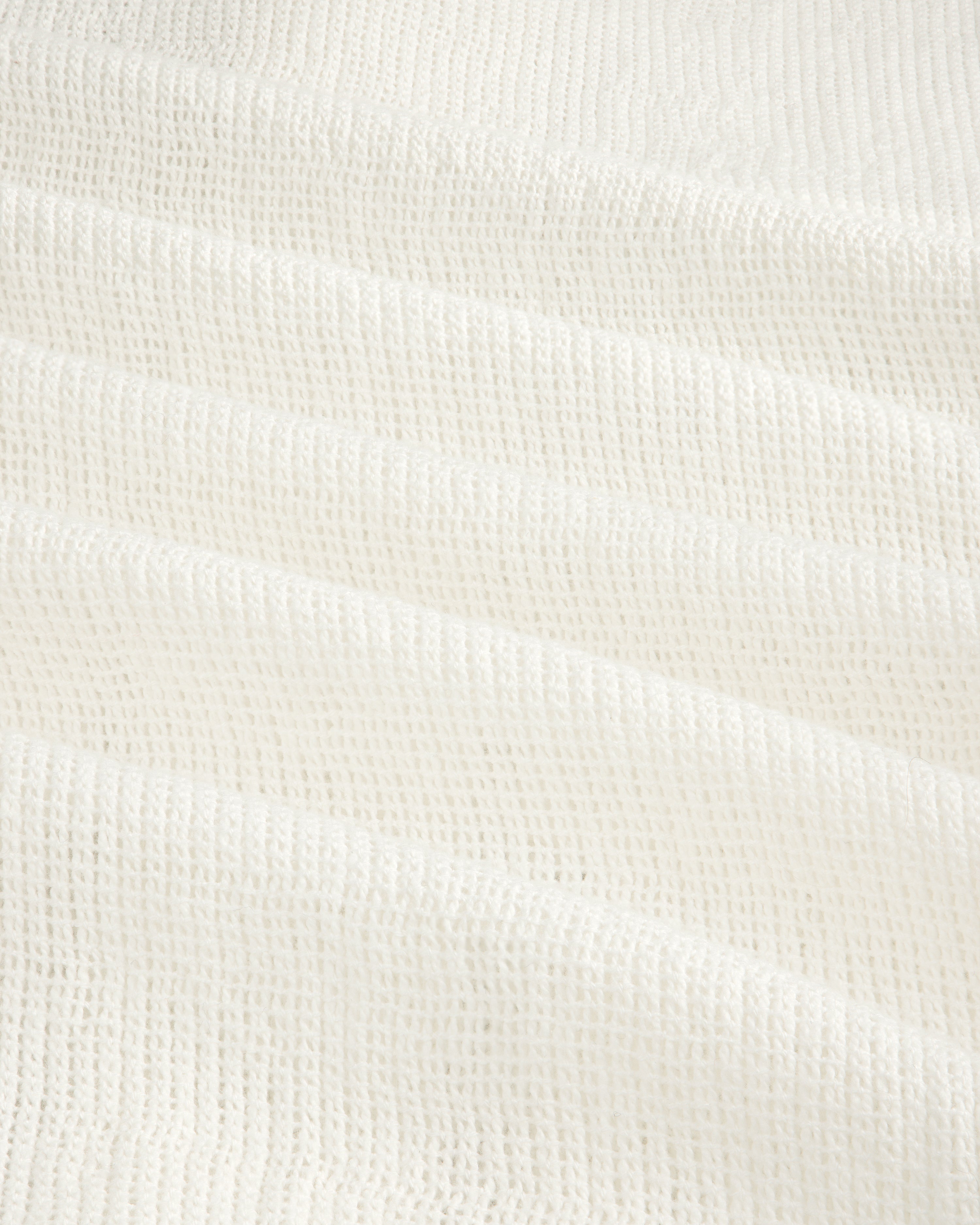 Close-up of the Mesh Jungle Shirt's white waffle-textured fabric with soft, grid-like ridges.