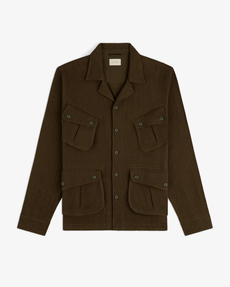 Mesh Jungle Shirt with a collar and four front buttoned flap pockets, laid flat on a white background.