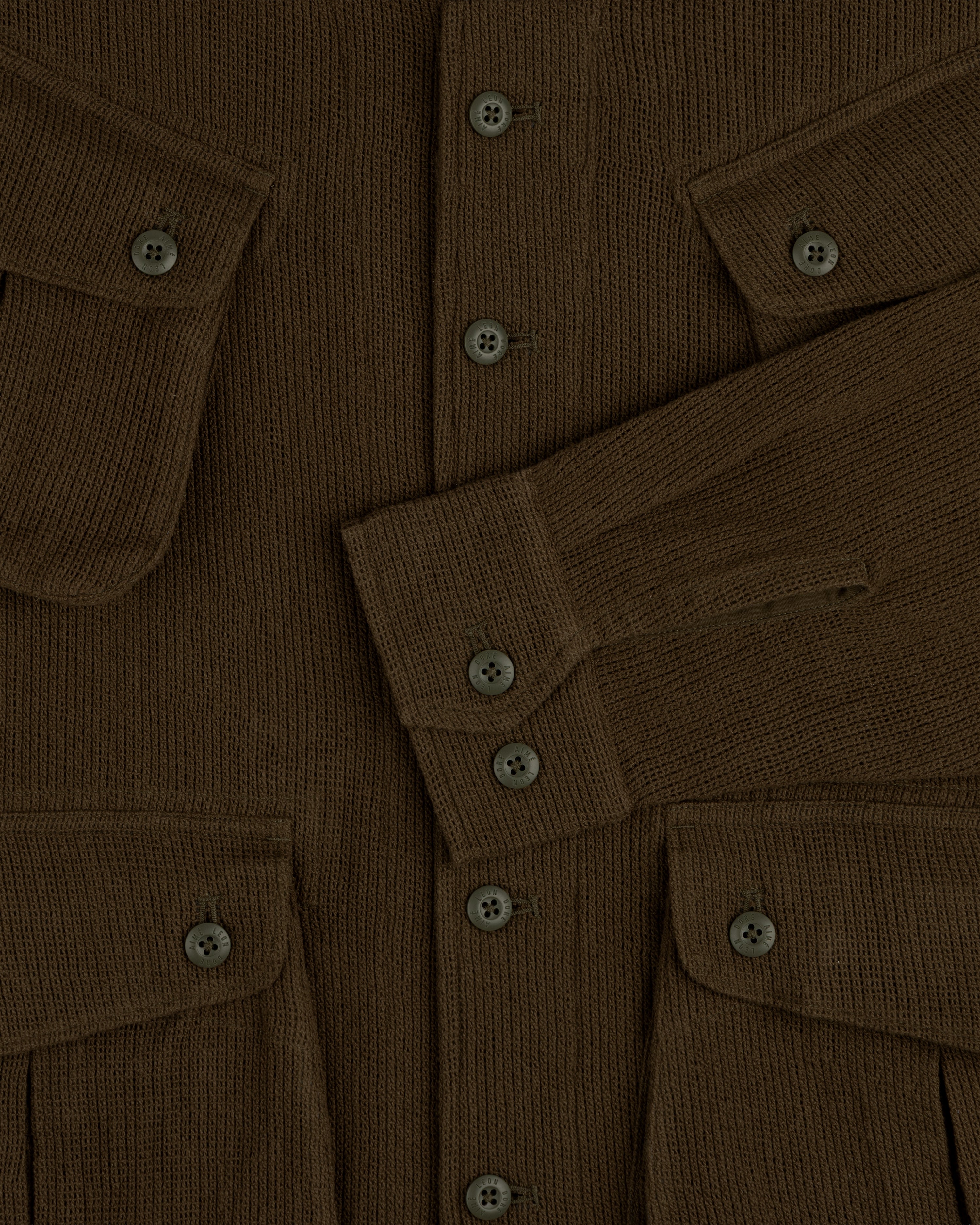 Mesh Jungle Shirt with buttoned front, flap pockets, and long sleeves overlapping at the center.