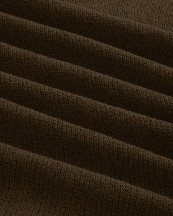 Close-up of the Mesh Jungle Shirt's brown, ribbed knit fabric with textured, evenly spaced horizontal folds.
