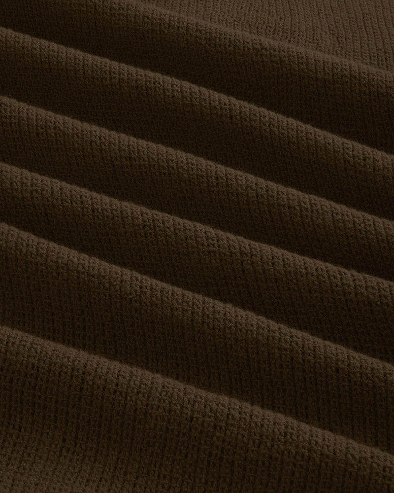 Close-up of the Mesh Jungle Shirt's brown, ribbed knit fabric with textured, evenly spaced horizontal folds.