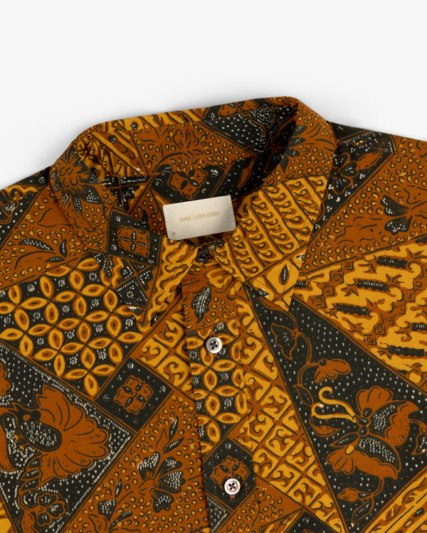 A close-up of the Printed Abstract Shirt featuring gold, black, and brown geometric and floral patterns.