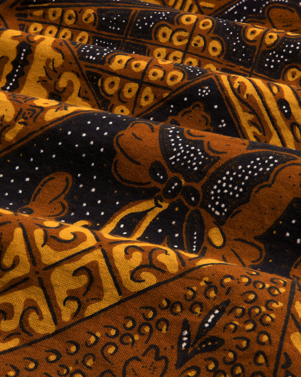 Close-up of the Printed Abstract Shirt featuring brown, black, and yellow batik with intricate floral and geometric patterns.