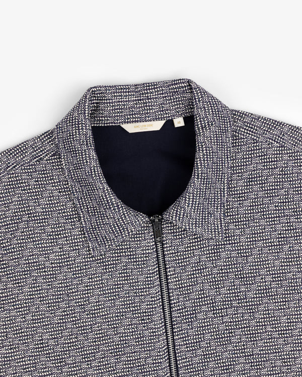 Close-up of the Textured Zip Shirt featuring navy and white patterned fabric and a stand collar.