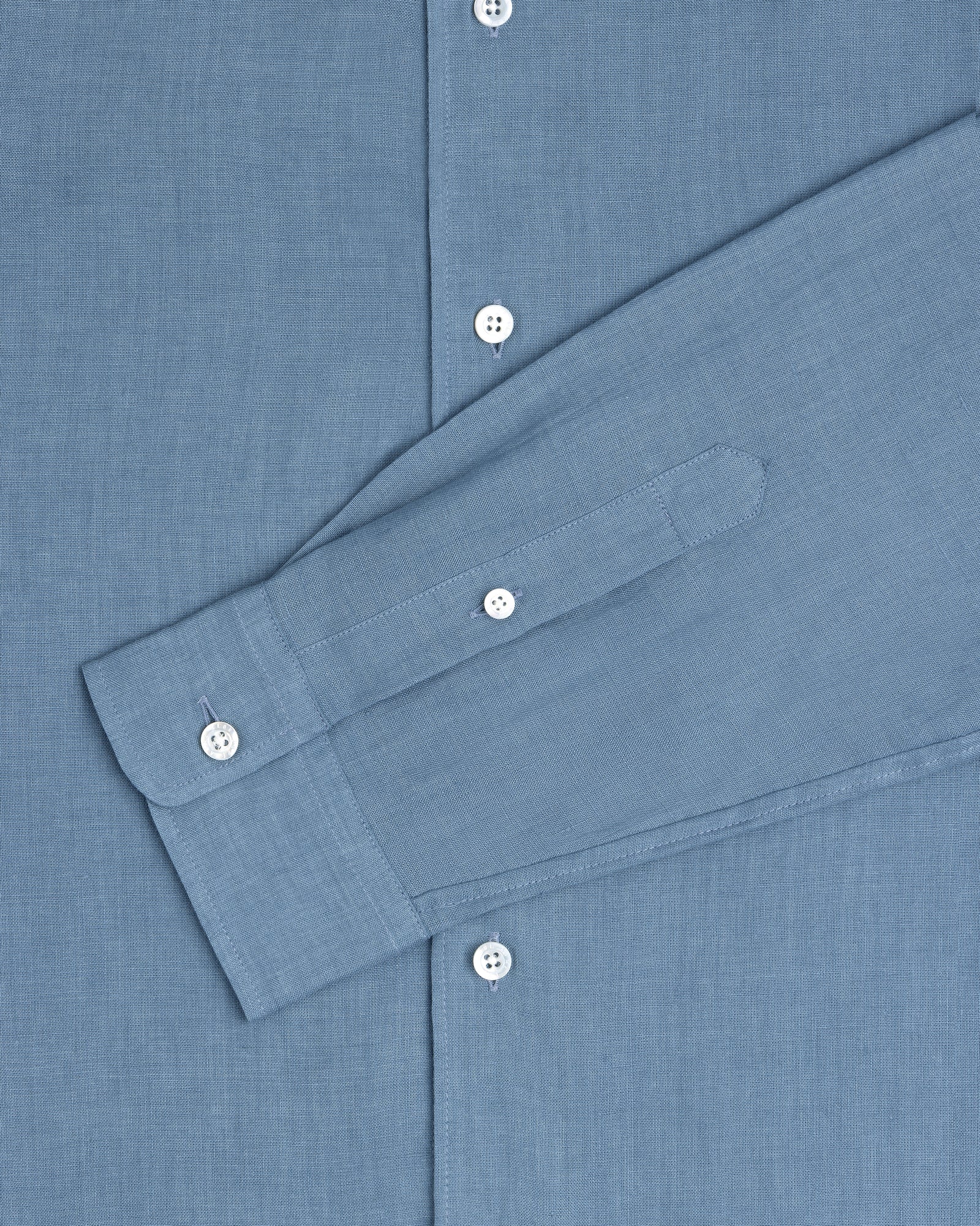 The Long-Sleeve Linen Shirt in blue features white buttons and is shown from chest to cuff.