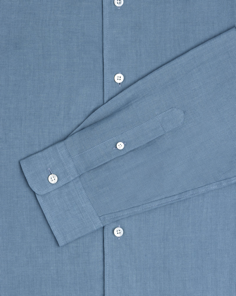The Long-Sleeve Linen Shirt in blue features white buttons and is shown from chest to cuff.