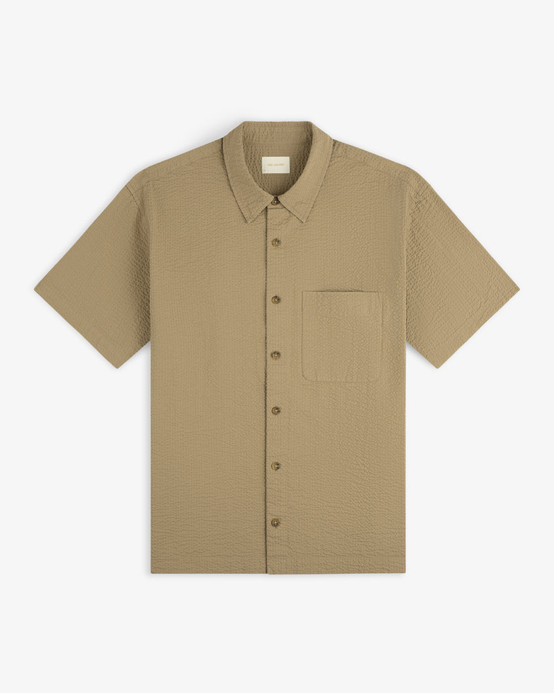 Short-Sleeve Seersucker Shirt in textured beige with front chest pocket, laid flat on a white background.