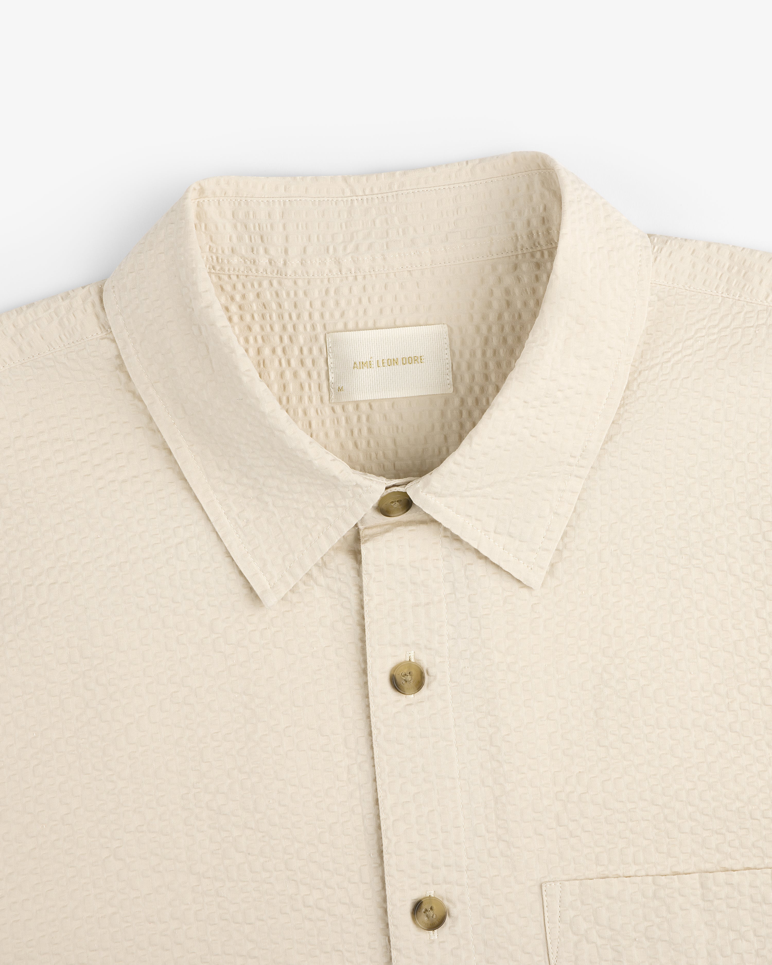 Short-Sleeve Seersucker Shirt in cream with buttons, collar, and chest pocket, shown from shoulders to mid-chest.