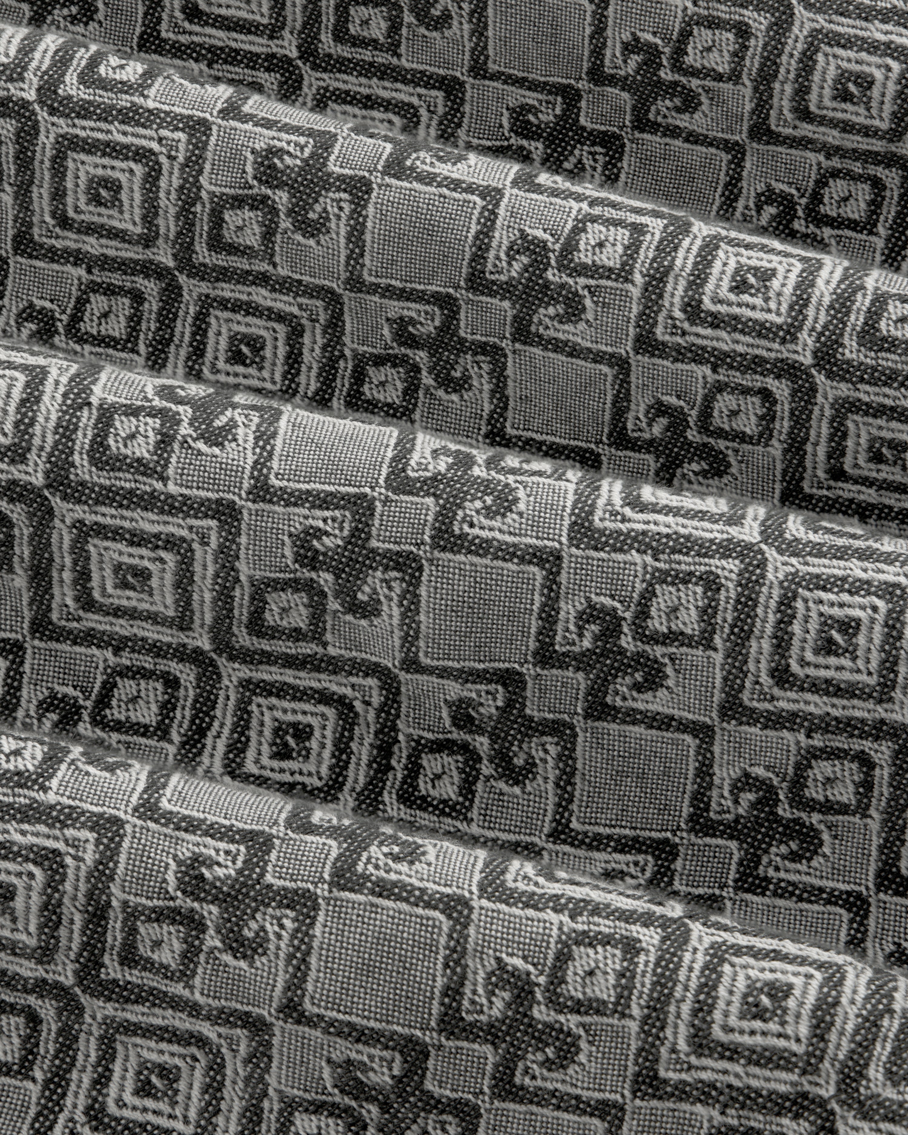 Jacquard Leisure Shirt in black and gray fabric features a geometric square pattern, shown with overlapping folds.