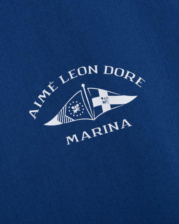 Blue fabric Marina Jacket featuring AIMÉ LEON DORE MARINA text and two white nautical flags printed below.