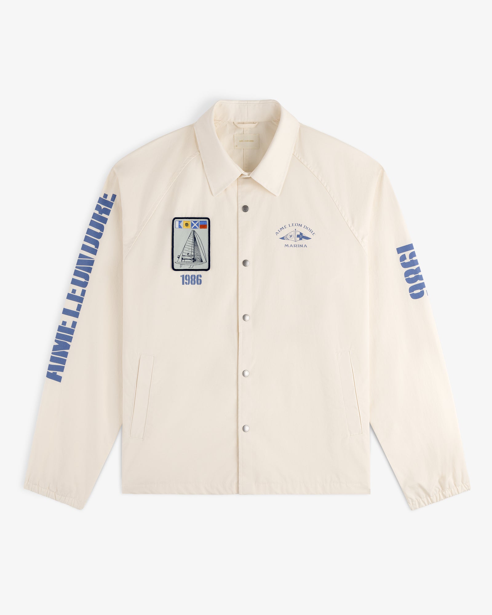 Marina Jacket: Beige button-up with blue graphics, ANNE LEMOINE on the sleeve, and nautical-themed patches.
