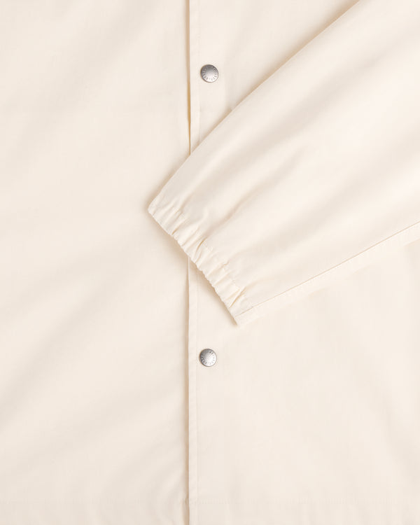 Close-up of the Marina Jacket in cream with silver snap buttons and elasticated sleeve cuffs.