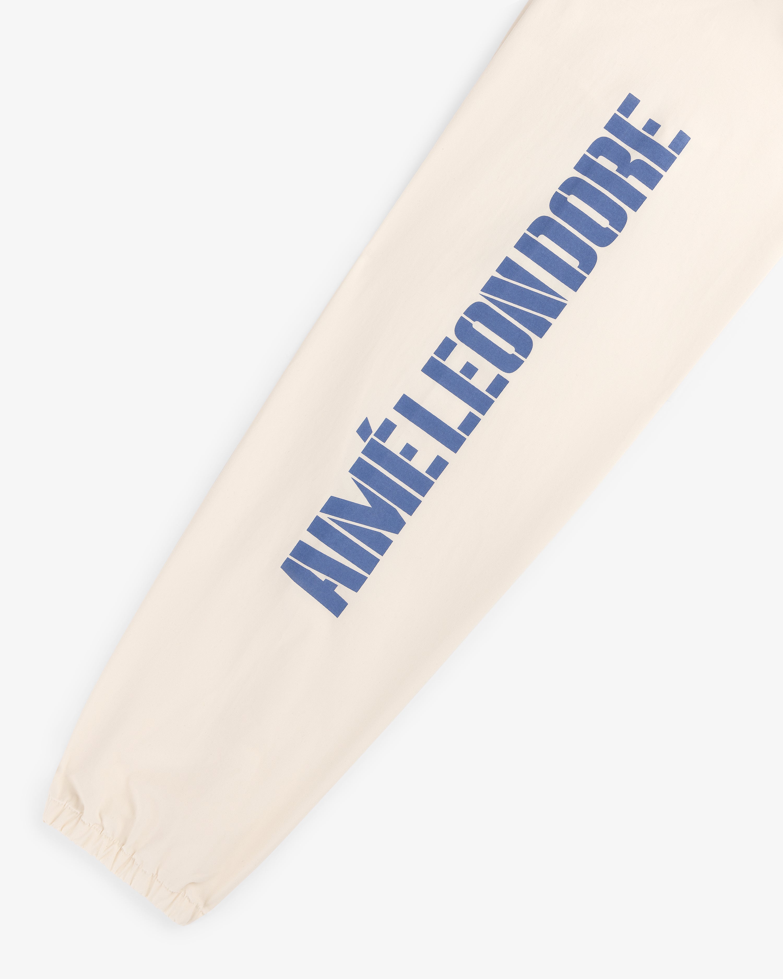 Cream-colored Marina Jacket sleeve with large blue AIMÉ LEON DORE print and an elastic cuff at the wrist.