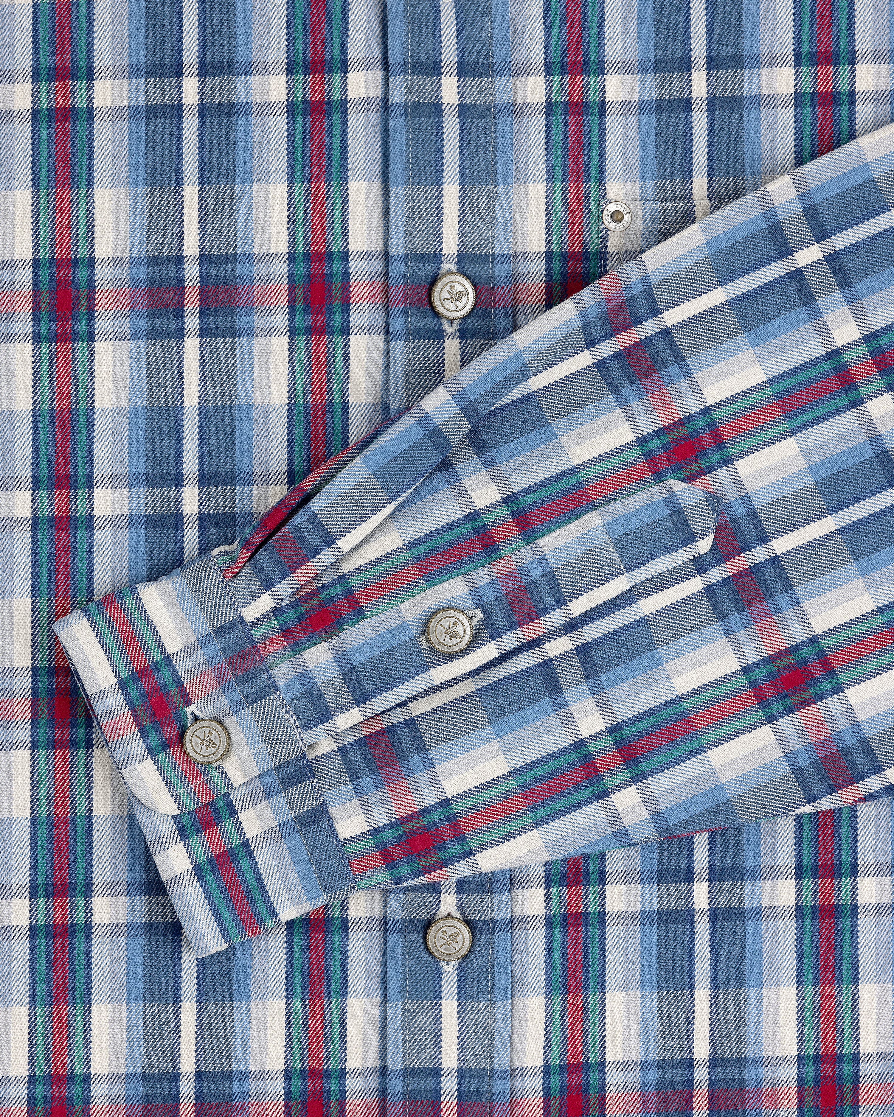 Plaid Work Shirt in blue, white, and red with button details and one sleeve folded across the front.