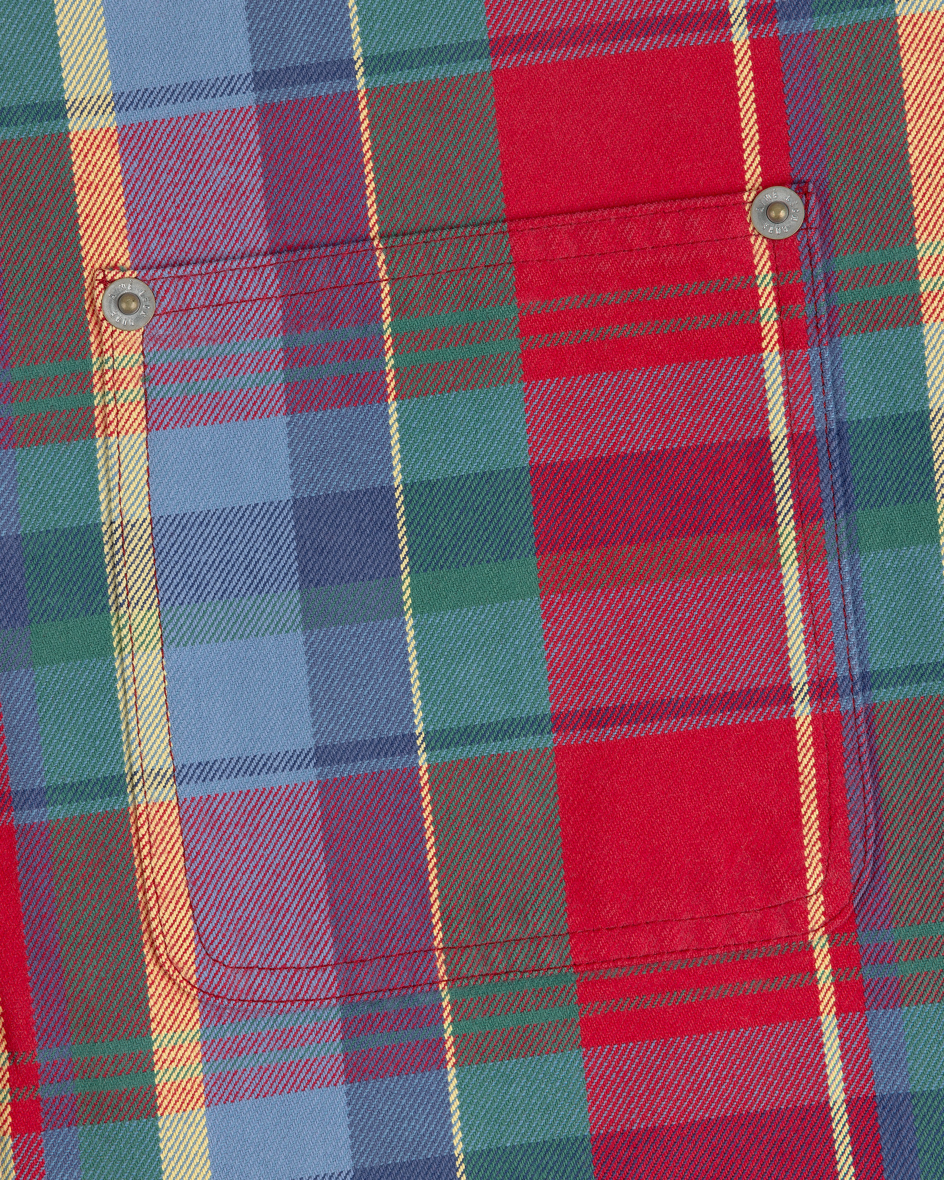 Close-up of the Plaid Work Shirt with a chest pocket, metal rivets, and red, blue, green, and yellow stripes.