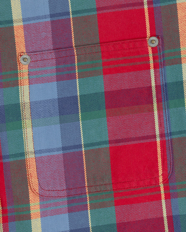 Close-up of the Plaid Work Shirt with a chest pocket, metal rivets, and red, blue, green, and yellow stripes.