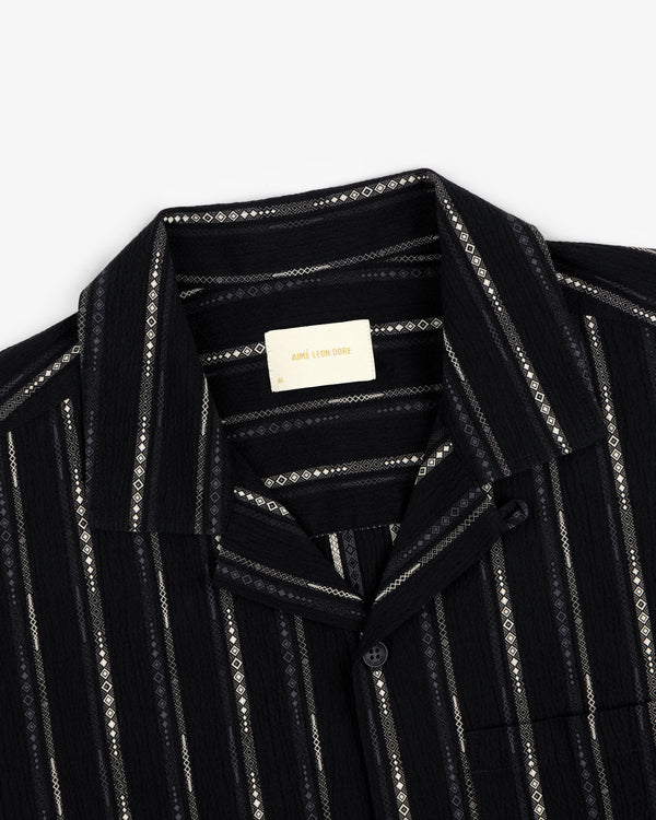 Cropped Jacquard Camp Shirt in black with vertical white and grey geometric stripes, shown from the neck down.