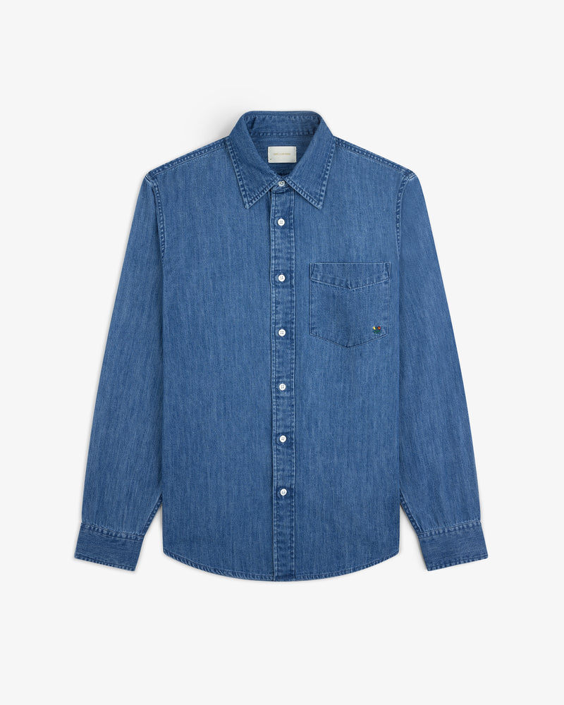 Crest Chambray Shirt: long-sleeve blue denim button-up with front chest pocket, laid flat on white background.