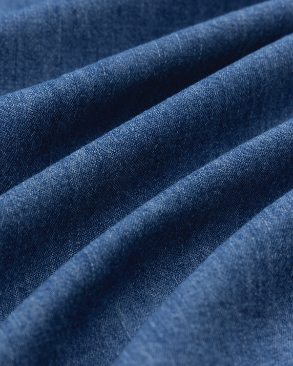 Close-up of Crest Chambray Shirt fabric, highlighting blue texture and diagonal ridges.
