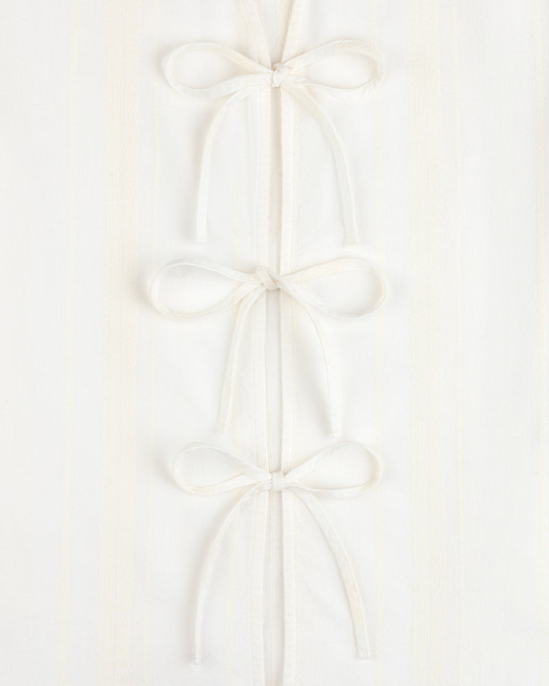 Jacquard Striped Tie-Front Shirt in white, featuring three fabric bows on a subtly striped background.