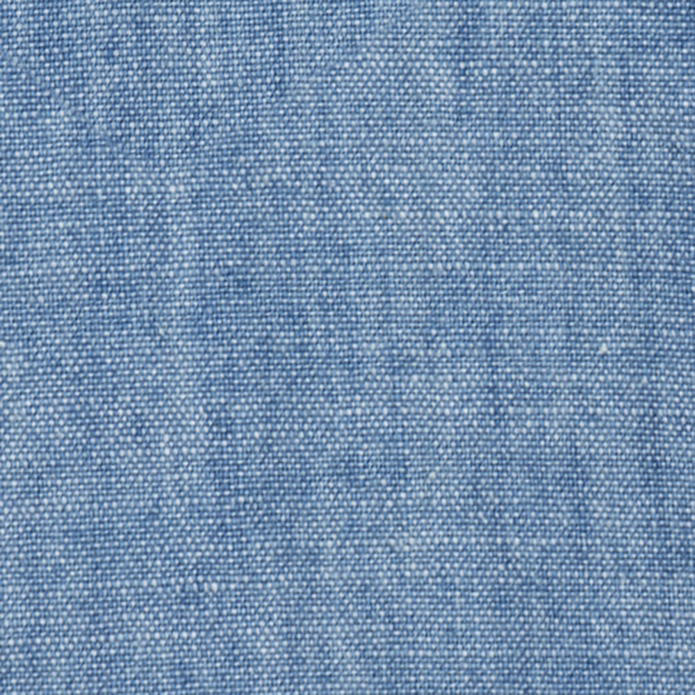 Close-up of Crest Chambray Shirt in light blue, highlighting woven threads and subtle color variations.