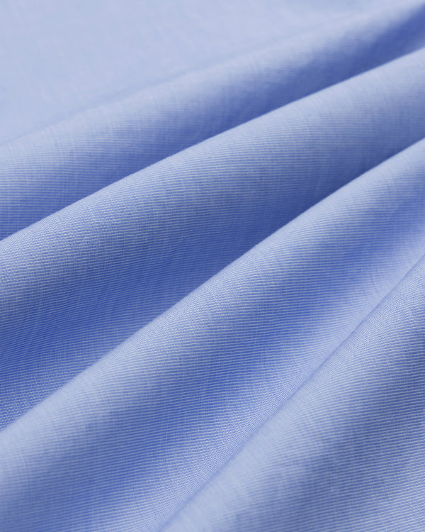 Close-up of Poplin Casual Shirt fabric in light blue, showing visible fibers, soft folds, and smooth texture.