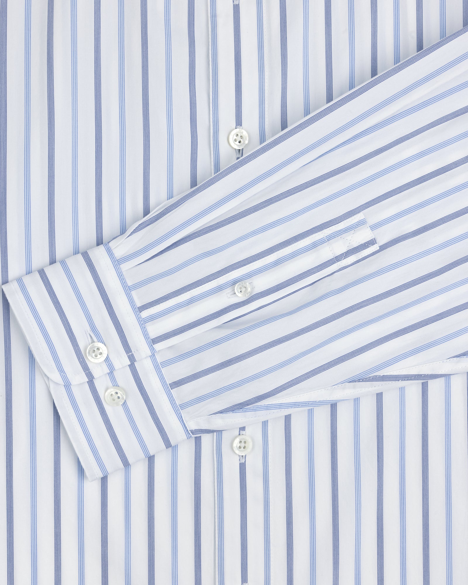 Close-up of a Poplin Casual Shirt, white with blue vertical stripes and white buttons on the cuff and front.