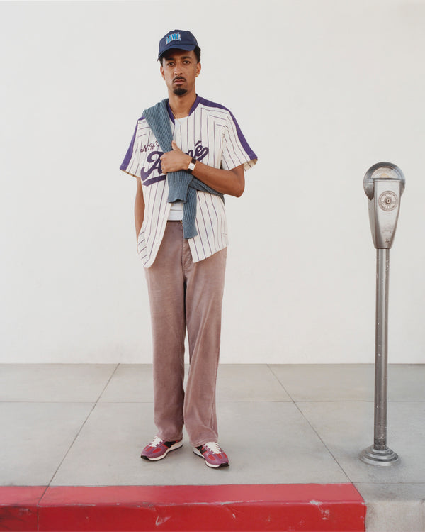 A man wearing Linen Blend Carpenter Pants stands by a parking meter on the sidewalk, looking at the camera.