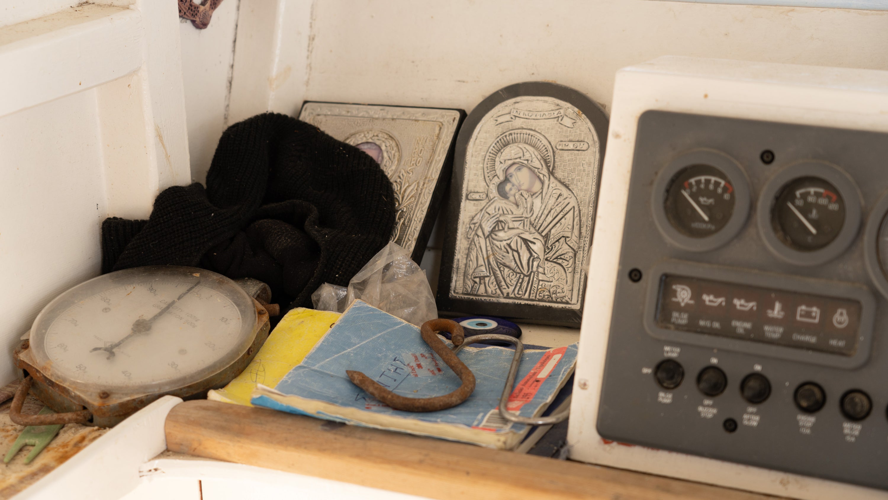 Collection of vintage items including a clock, books, and a religious icon on a wooden surface.