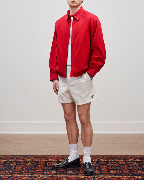 A person wearing a Crest Casual Jacket, white shorts, socks, and black loafers stands on a patterned rug.