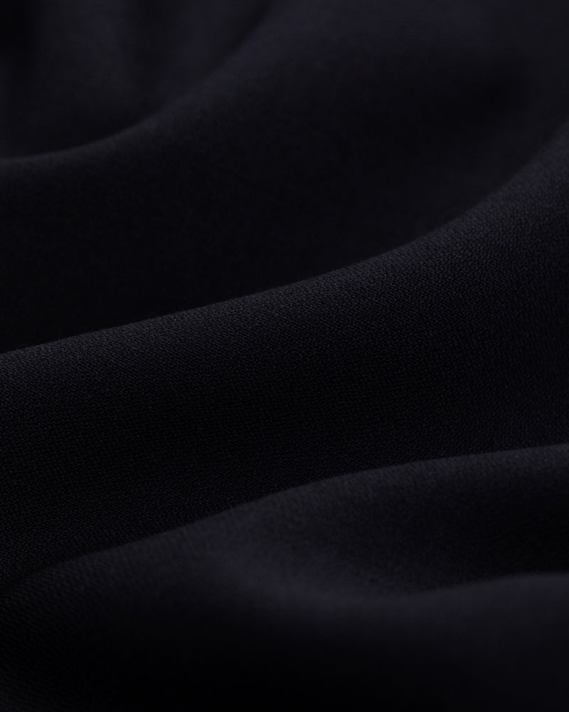 Close-up of Tropical Wool Suit Trouser fabric with soft folds and a smooth, wavy texture.