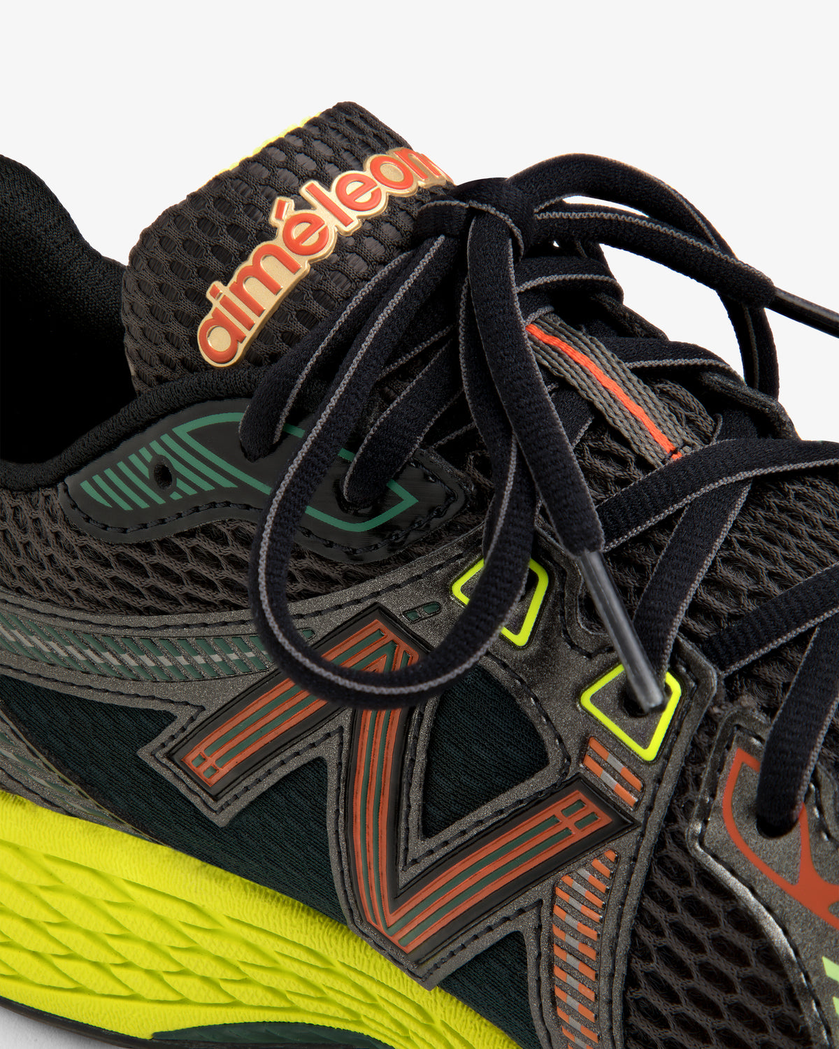 Close-up of the ALD / New Balance 860v2, a black sneaker with colorful accents, black laces, and branded tongue.